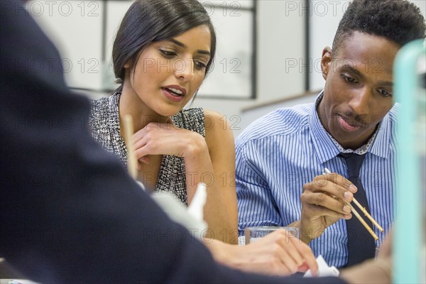 People eating with chopsticks in meeting