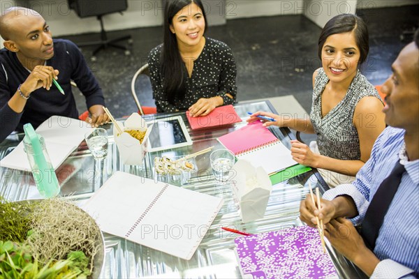 People eating with chopsticks in meeting