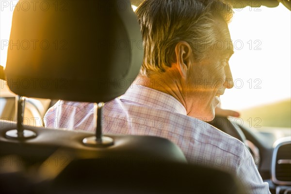 Smiling Caucasian man driving car