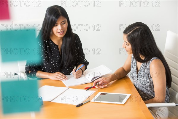 Women reading notebooks in meeting