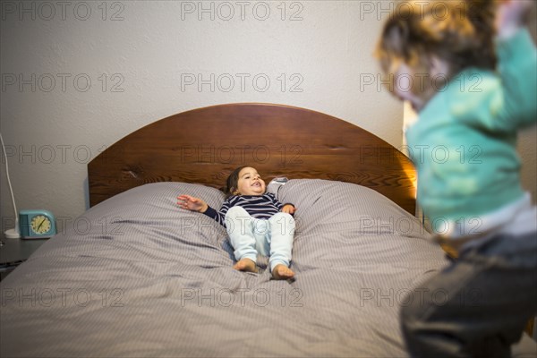 Mixed Race girls playing on bed