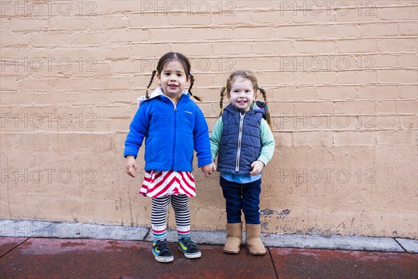 Girls holding hands on sidewalk