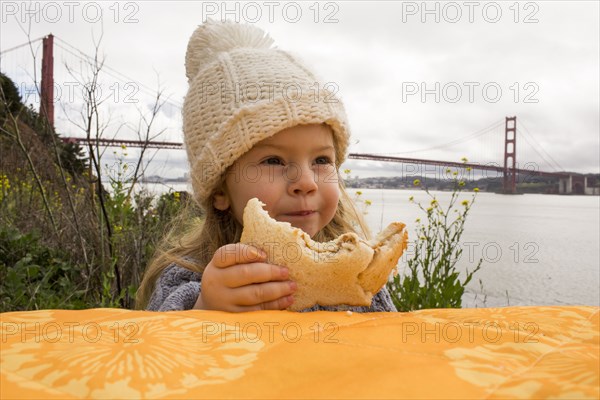 Caucasian girl eating sandwich outdoors
