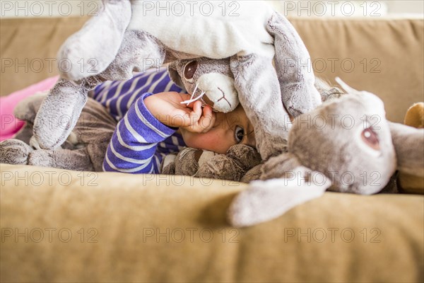 Caucasian girl laying on sofa sucking thumb