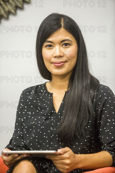 Portrait of Asian woman holding digital tablet