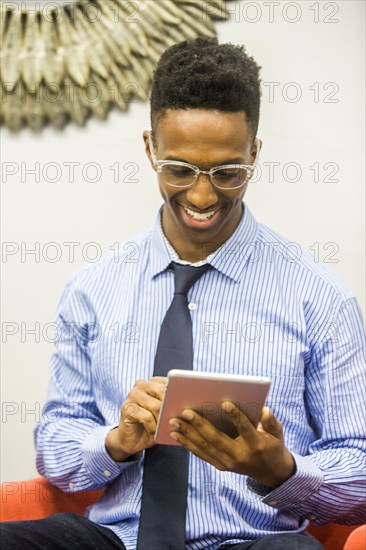 Smiling Black businessman using digital tablet