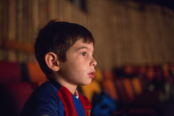 Mixed Race boy watching movie in theater