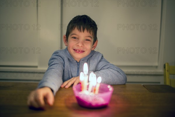 Mixed Race boy smiling near burning candles