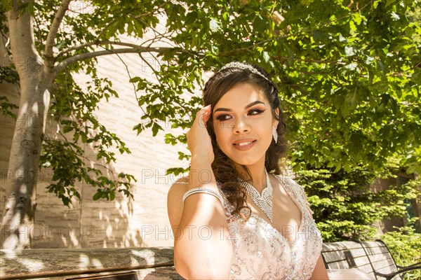 Smiling Hispanic girl under a tree