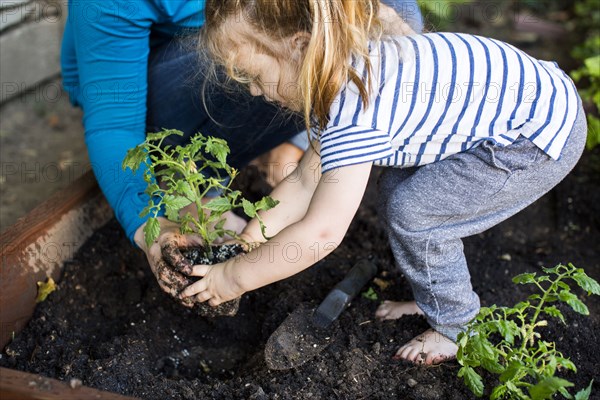 Caucasian mother teaching gardening to daughter