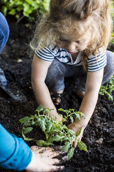 Caucasian mother teaching gardening to daughter