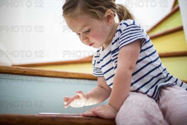 Caucasian girl using digital tablet on staircase