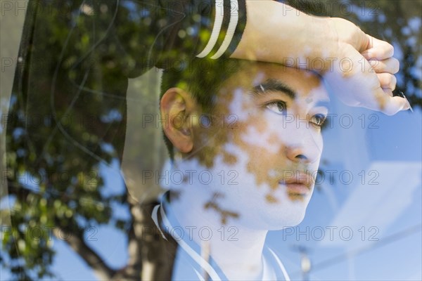 Serious Chinese man leaning on window