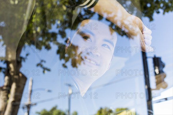 Smiling Chinese man leaning on window