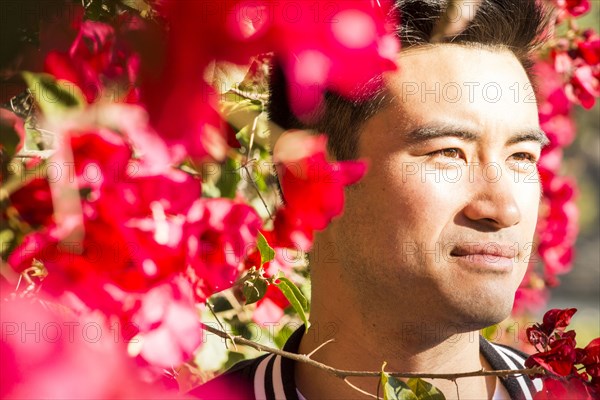 Portrait of smiling Chinese man near flowering tree