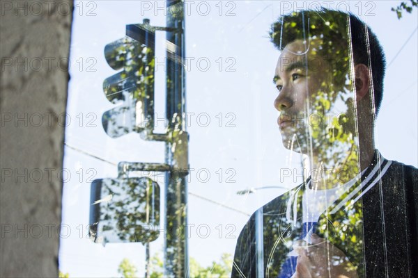 Portrait of serious Chinese man behind window