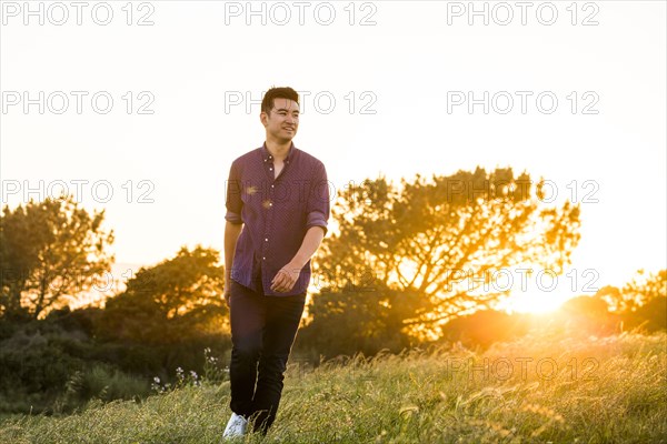 Smiling Chinese man walking on hill