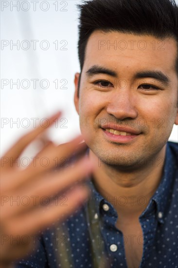 Smiling Chinese man examining grass