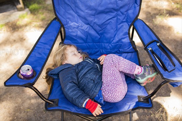 Caucasian girl sleeping on folding chair