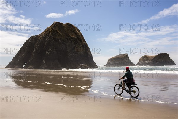 Caucasian woman riding bicycle on beach