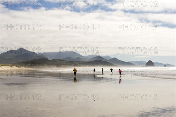 Distant people running on beach