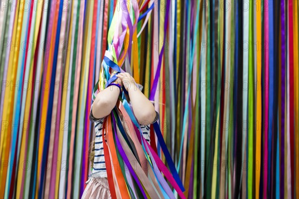 Caucasian girl playing with colorful hanging streamers