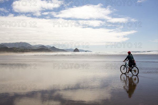 Caucasian woman riding bicycle on beach