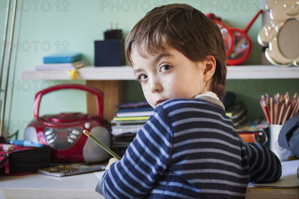 Caucasian boy giving doing homework at desk