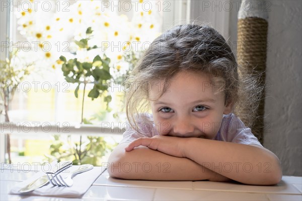 Caucasian girl leaning on kitchen table