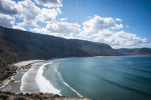 Ocean waves on beach under mountains