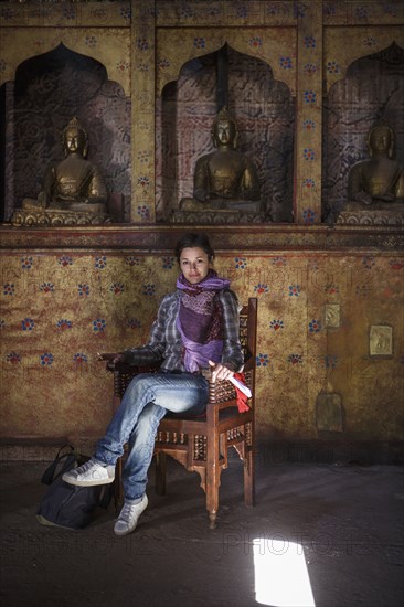 Caucasian woman sitting in chair in temple