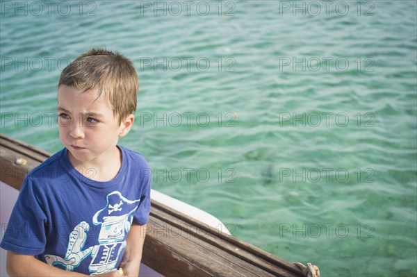 Caucasian boy on boat in water