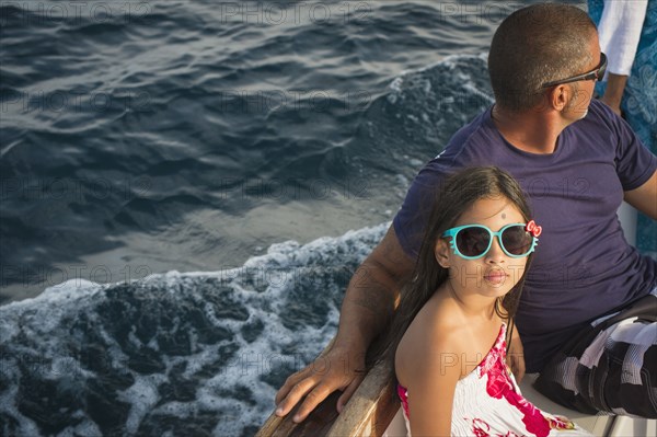 Father and daughter sitting on boat