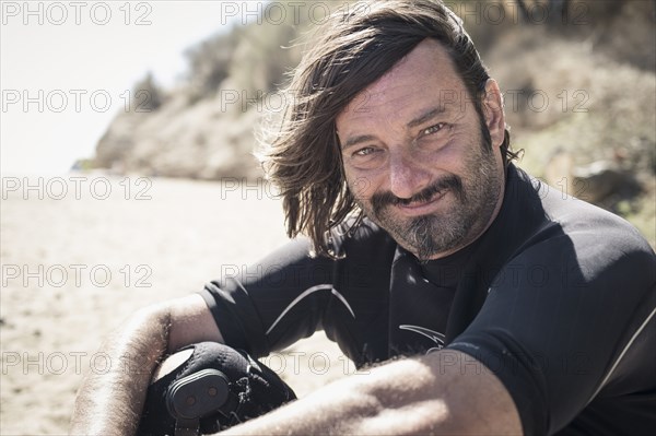 Caucasian surfer smiling on beach