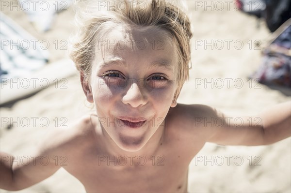 Smiling Caucasian boy standing on beach