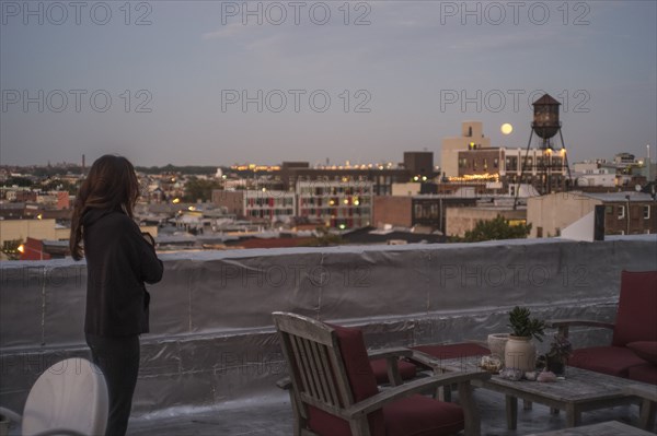 Caucasian woman admiring cityscape from urban rooftop
