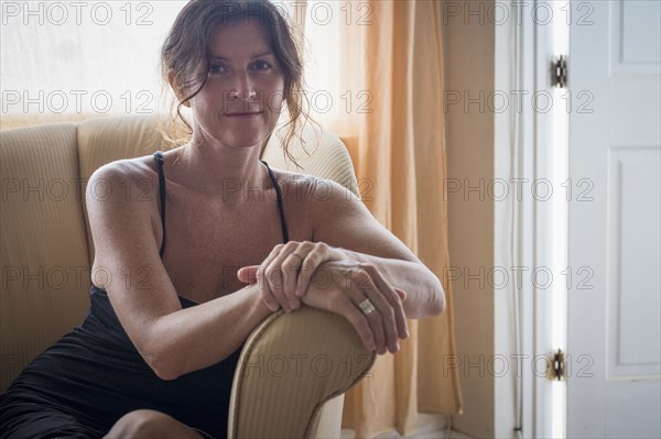 Caucasian woman sitting in armchair in living room