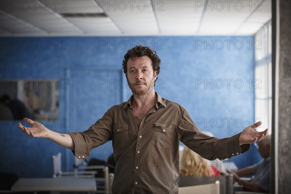 Caucasian man standing with arms outstretched in living room