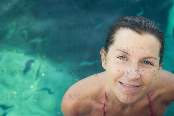 Caucasian woman smiling in swimming pool