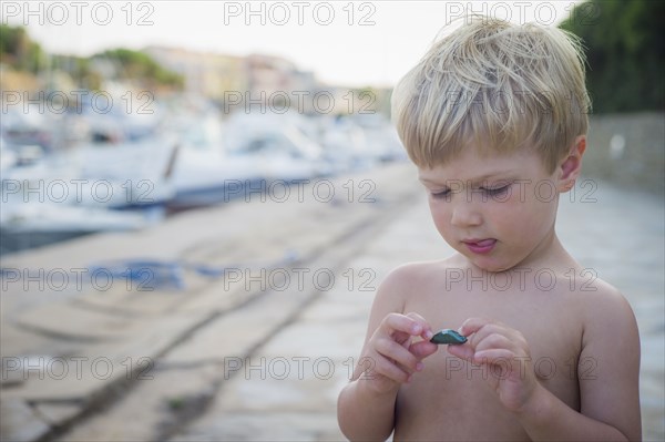 Curious Caucasian boy playing with rock