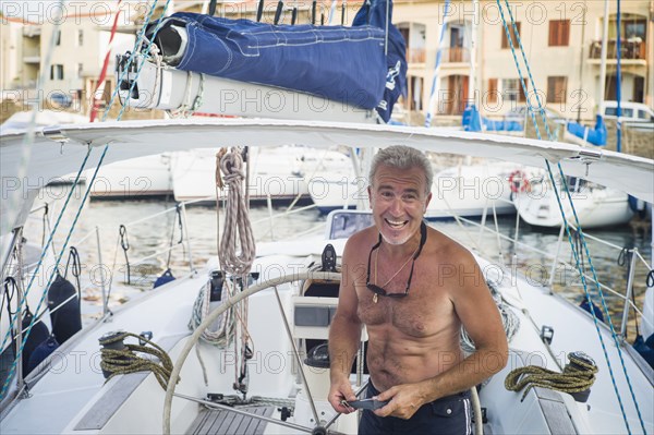 Caucasian man standing on boat docked in harbor