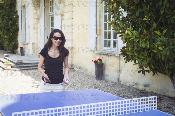 Caucasian woman playing table tennis in yard