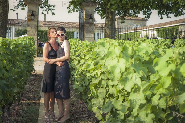 Caucasian lesbian couple hugging in vineyard