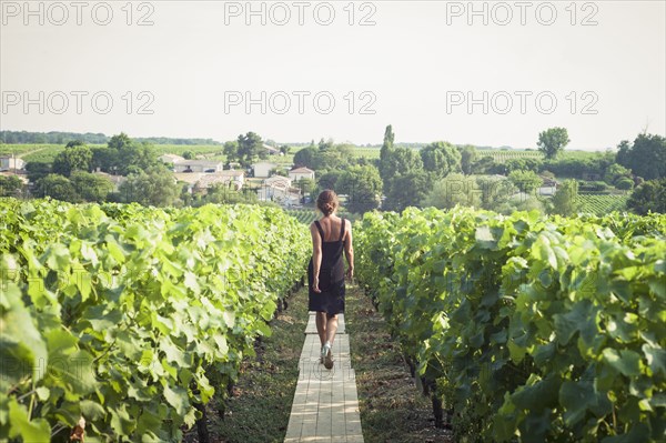 Caucasian woman walking on wooden walkway in vineyard