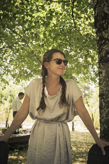 Caucasian woman wearing sunglasses under tree