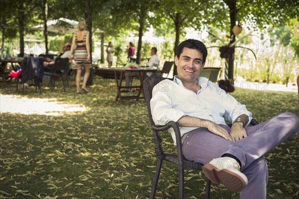 Caucasian man sitting in chair in backyard