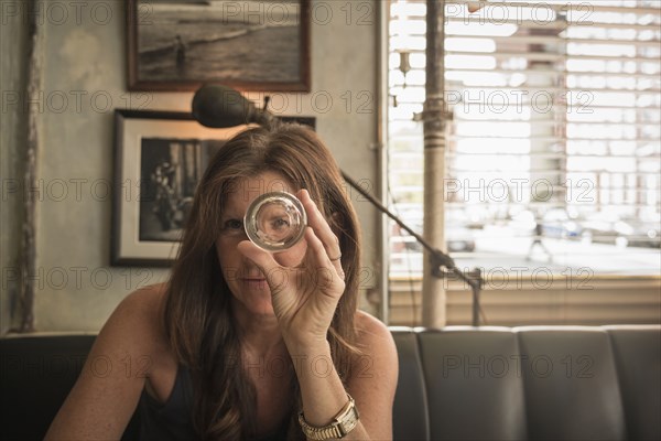 Caucasian woman looking through empty glass in cafe