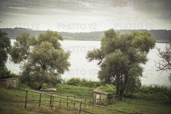 Fences around rural fields near still lake