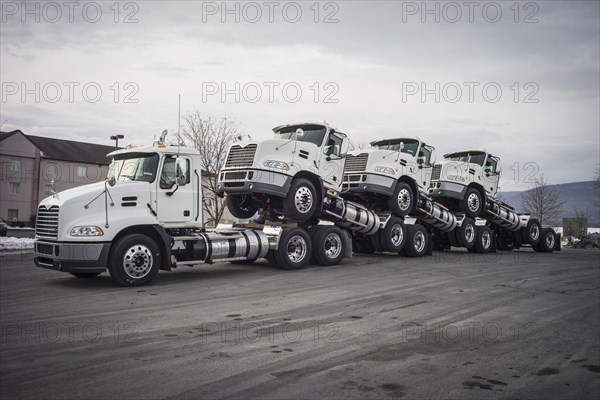 Truck towing truck engines on dirt road