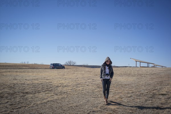 Caucasian woman walking in empty field